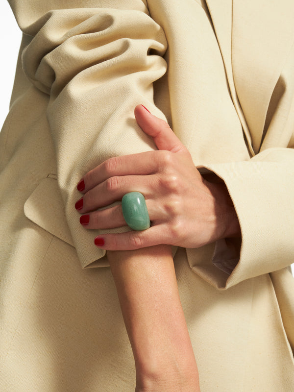 Dłoń modelki z dużym zielonym pierścionkiem z kamienia