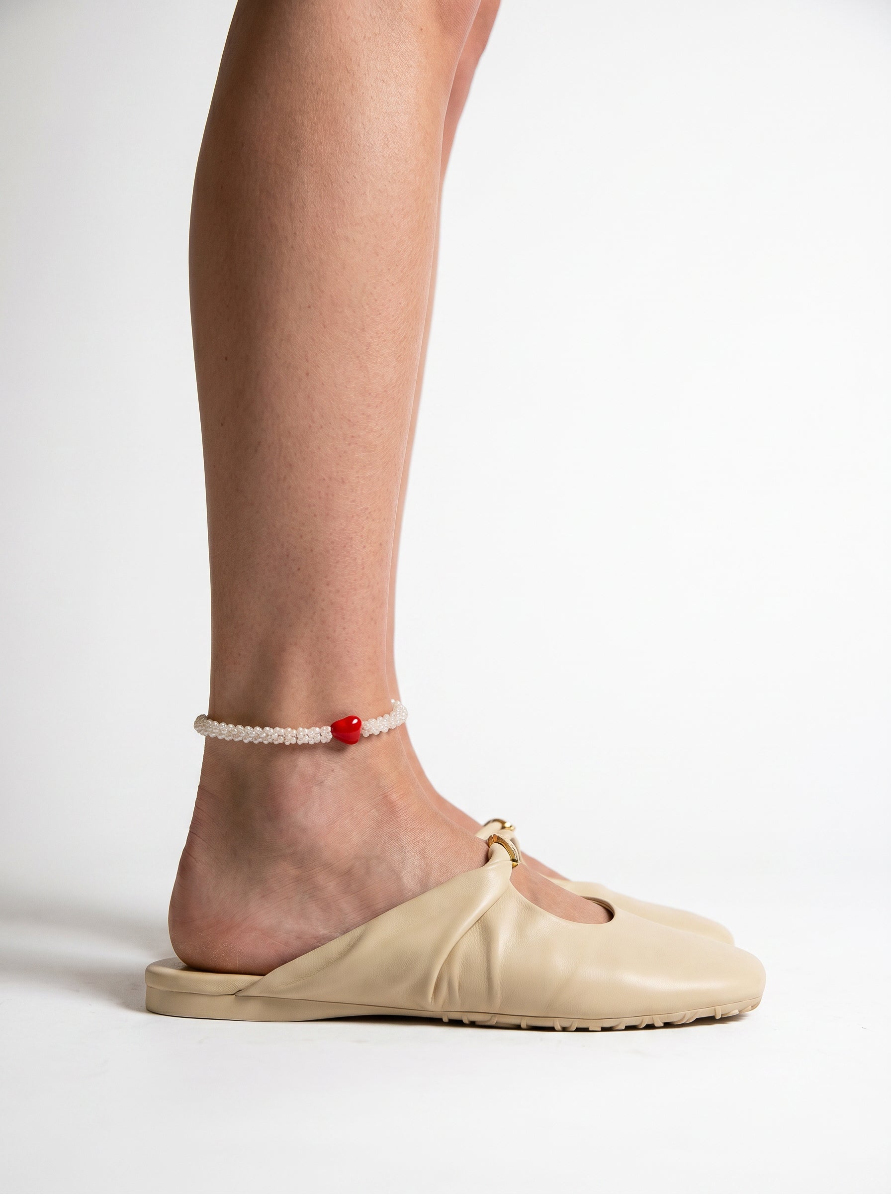Ankle bracelet with white beads and a red accent 1