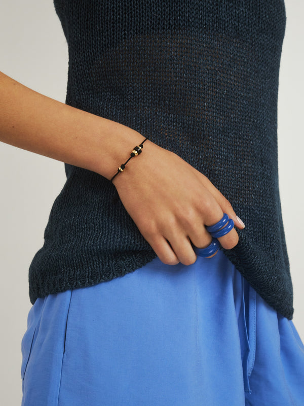 Czarna bransoletka na sznurku z czarnym obsydianem i pozłacanymi kuleczkami.