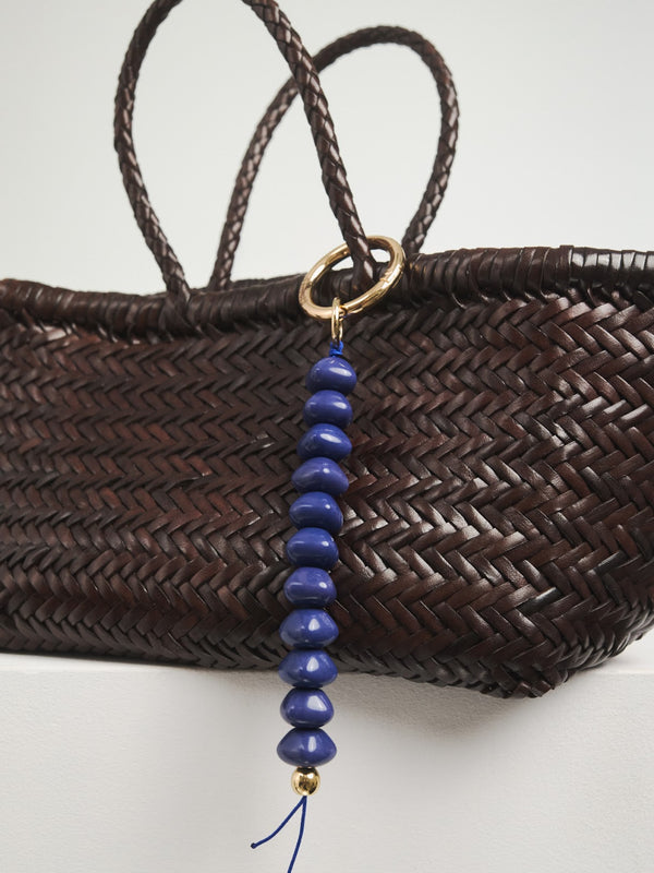 Duży brelok w niebieskim kolorze w zestawieniu z torebką