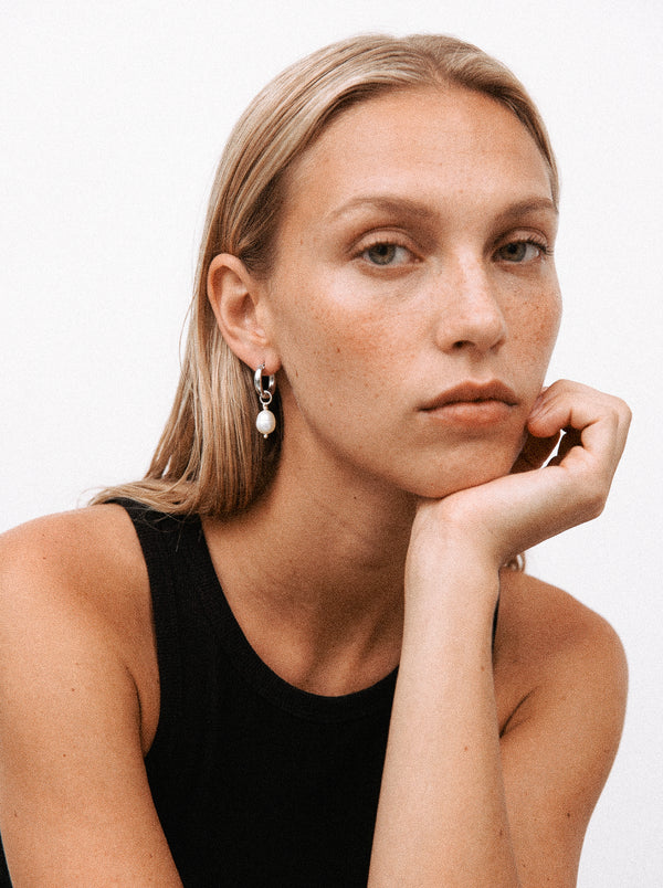 Srebrny kolczyk z zawieszką z perły hodowlanej na modelce.