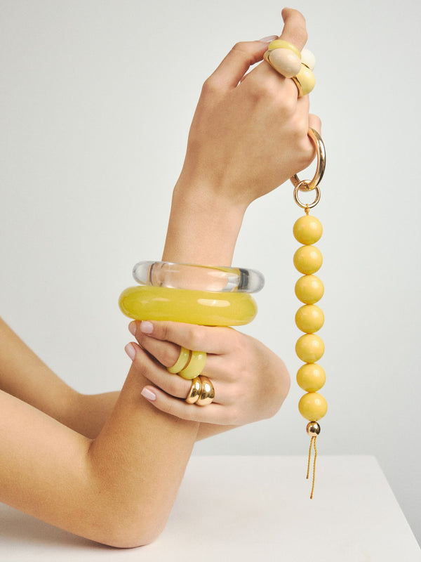 Duży brelok z żywicy w kompozycji z żółtą i pozłacaną biżuterią marki Berries