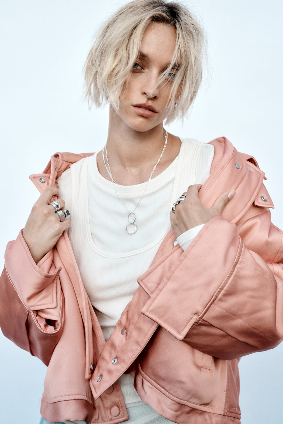 Model wearing a pink jacket and ESSENTIALS jewellery